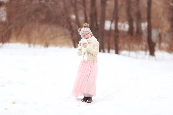 Cute girl hugging a stuffed toy winter day in the forest