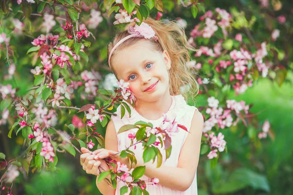 Cute spring  fashion girl under blossom apple tree