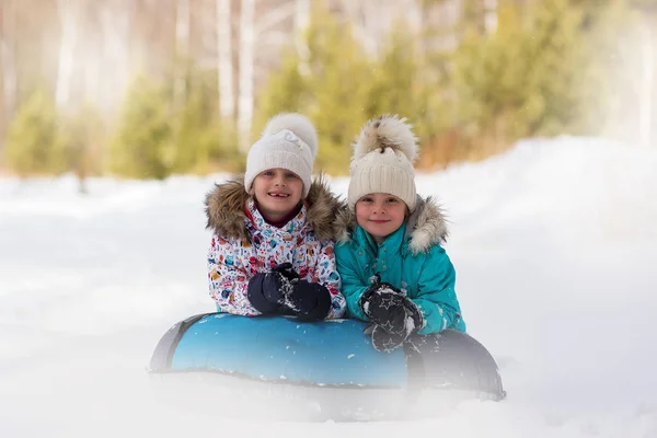 Fröhliche Mädchen Reiten Gemeinsam Einen Schlauch Von Einem Hügel Winterurlaub — Stockfoto