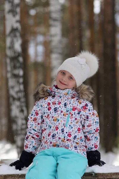 雪に覆われた冬の森を歩く 代の笑顔の少女 — ストック写真