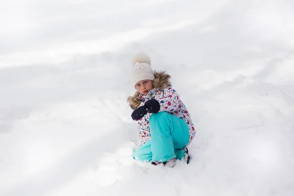 冬に雪に覆われた森に座って泣いている悲しい少女雪に染まった服 — ストック写真