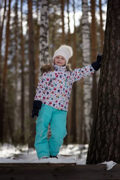 雪に覆われた冬の森を歩く 代の笑顔の少女 — ストック写真