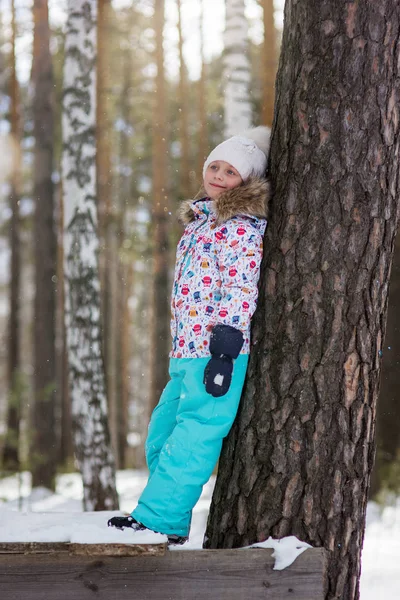 雪に覆われた冬の森を歩く 代の笑顔の少女 — ストック写真