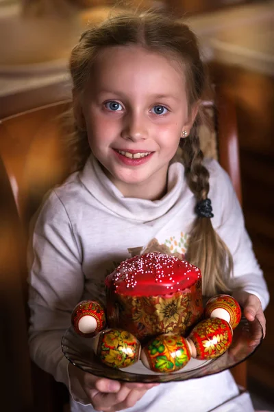 아름다운 소녀는 부활절 케이크와 달걀을 접시에 카메라를 웃는다 부활절 — 스톡 사진