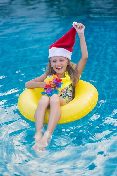 Mała Blondynka Kapeluszu Mikołaja Pływanie Basenie Koncepcja Świętowania Bożego Narodzenia — Zdjęcie stockowe