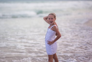 Denizin arka planında beyaz elbiseli mutlu bir Rus kızının portresi. Çocuk temiz havada yürür. Tatil.