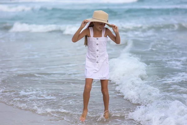 白いドレスと海の背景に帽子で幸せなロシアの少女の肖像画 子供は新鮮な空気の中を歩く — ストック写真
