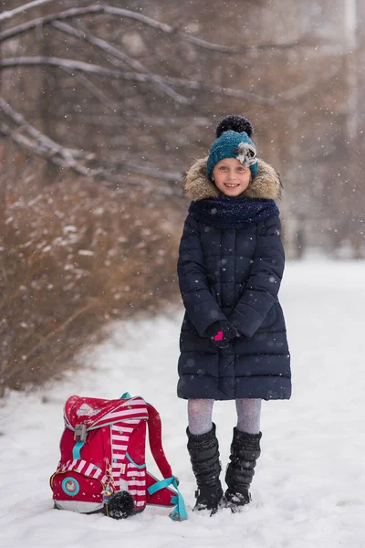雪の公園で学校の後のブリーフケース付きの楽しい女の子の学生 — ストック写真