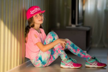 Çok renkli takım elbiseli genç bir jimnastikçi kameraya bakıyor. Modern koreografiyle dans eden kız. Hip Hop Kızı.