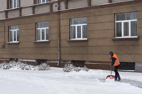 Уборщик убирает снег на улицах города — стоковое фото