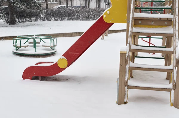 Parco giochi per bambini in inverno nevicate innevate . — Foto Stock