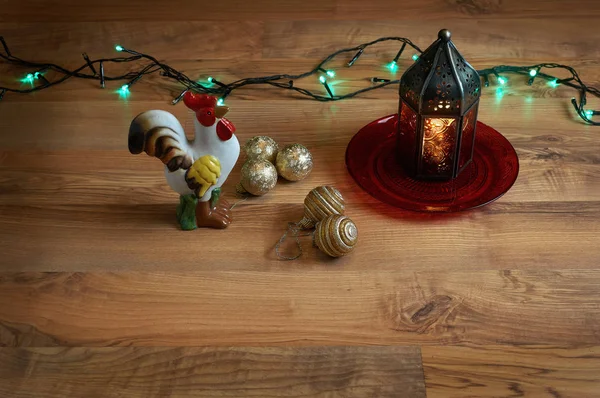 Rött ljus med en tupp och träd dekorationer — Stockfoto
