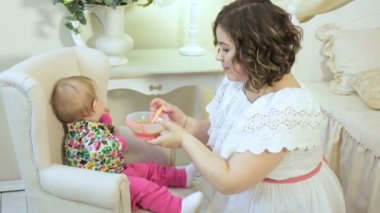 Beyaz elbiseli güzel bir kadın bir çocuk beslenme ve yemek reddediyor