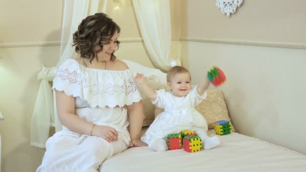 Máma a dcera sedí na posteli, hrací kostky a s úsměvem — Stock video