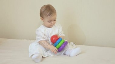 Beyaz elbiseli bir piramitte oynarken küçük gülümseyen kız