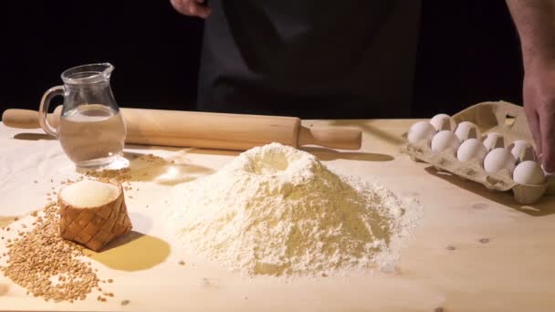 El cocinero rompe el huevo en harina con un cuchillo — Vídeos de Stock