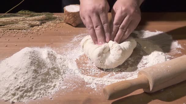 De kok kneedt het deeg met beide handen op tafel bloem-gegoten — Stockvideo