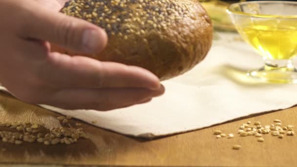 Close-up. Pão polvilhado com sementes de girassol é colocado sobre a mesa — Vídeo de Stock