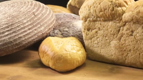 На столе кружится хлеб разных сортов — стоковое видео