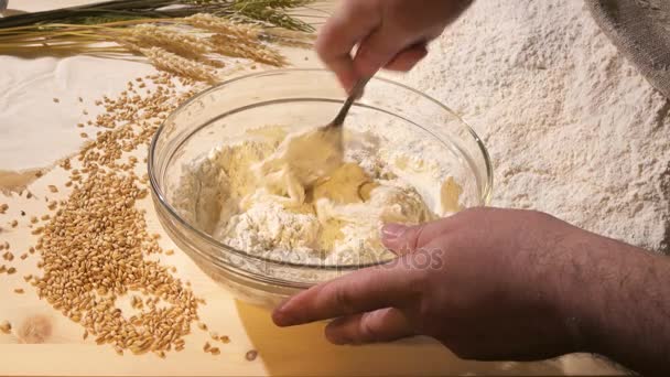 В стеклянной миске, повар разминает толстое тесто — стоковое видео