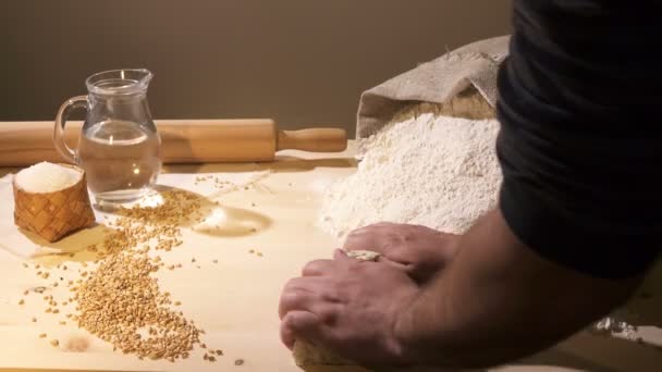 El cocinero frota la masa sobre una mesa llena de harina — Vídeos de Stock