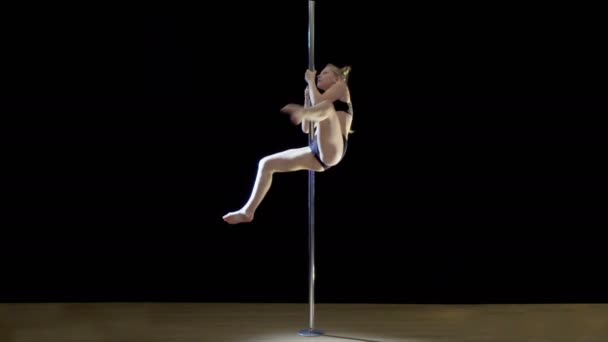 Pole Dance.Young blonďatá žena ukazuje fragmenty tance na černém pozadí — Stock video