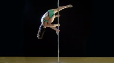 Pole Dance. Esmer güzel bir streç bir siyah arka plan üzerinde gösterir.