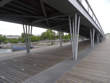 Bercy popüler bir arenadır ve yanına park eder. Paris, Fransa 'da. Parkta ve köprüde yürü. Yoldan geç Simone-de-Beauvoir Seine nehri üzerinde.