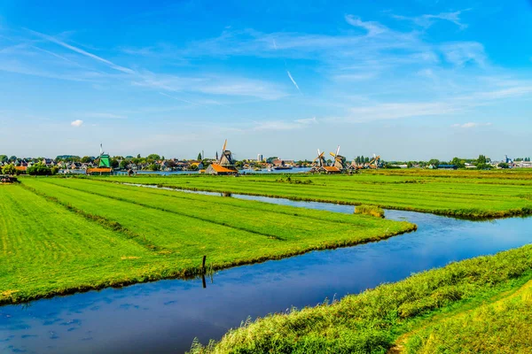 Typisk nederlandsk landskap med åpne enger, kanaler og nederlandske vindmøller – stockfoto