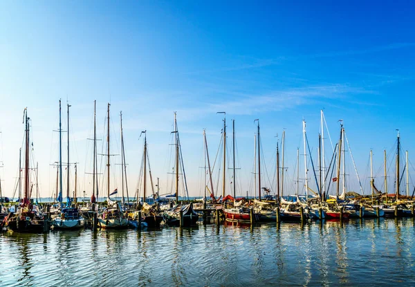 Puesta de sol sobre veleros amarrados en el pequeño puerto del histórico pueblo pesquero de Marken — Foto de Stock