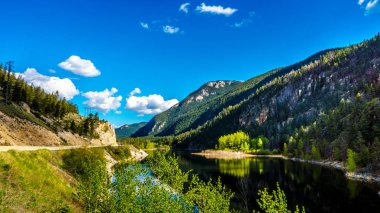 Mavi gökyüzü, ağaçlar ve dağlar kristal pürüzsüz yüzeyi yansımaları berrak su Crown Gölü