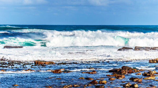 Волны Атлантического океана прорываются на скалистые берега мыса Доброй Надежды
