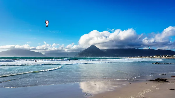 Kitesurfing v plážová komunita Het Kommitjie na pobřeží Atlantského oceánu — Stock fotografie