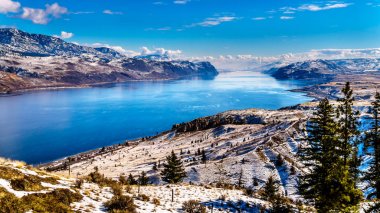 Merkezi British Columbia, Kanada'da mavi gökyüzü altında soğuk ve gevrek bir kış gün gölde Kamloops çevreleyen kar kaplı dağlar