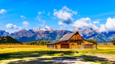 Mormon Row 'da terk edilmiş bir ahır. Arka planda bulutlar var. Grand Tetons Tepeleri Grand Tetons Ulusal Parkı' nda Jackson Hole, Wyoming yakınlarında.