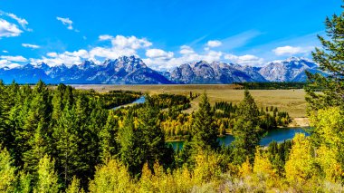 Wyoming 'deki Grand Tetons Ulusal Parkı, 191 no' lu otobanda Snake River Overlook 'dan izlenen kıvrımlı Yılan Nehri' nin arkasındaki Grand Tetons tepeleri