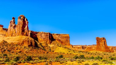 ABD 'nin Utah kentindeki Moab yakınlarındaki Arches Ulusal Parkı' nın çöl manzarasında Arches Scenic Drive boyunca uzanan uzun ve kırılgan kum taşı pinnacles.