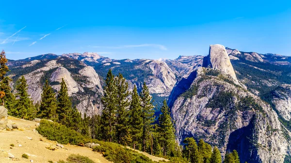 View from Glacier Point at the end of Glacier Point Road of the Sierra Nevada high country, with the curved tooth of the famous Half Dome in the foreground in Yosemite National Park, California, USA