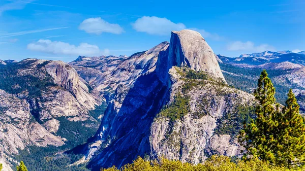 View from Glacier Point at the end of Glacier Point Road of the Sierra Nevada high country, with the curved tooth of the famous Half Dome in the foreground in Yosemite National Park, California, USA