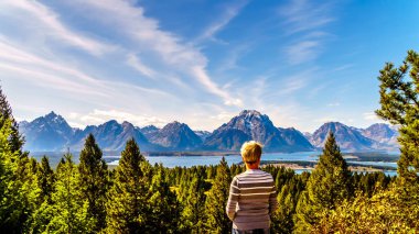 Jackson Gölü manzarası ve Teton Sıradağları 'nın yüksek tepelerinin keyfini çıkaran kadın Birleşik Devletler' in Wyoming kentindeki Grand Teton Ulusal Parkı 'ndaki Sinyal Dağı' ndan izleniyor.