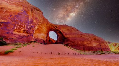 Rüzgâr Kulağı 'nın arkasındaki yıldızlı gökyüzü ABD' nin Arizona ve Utah sınırındaki Navajo kabile parkında bir kaya oluşumunda bir delik.