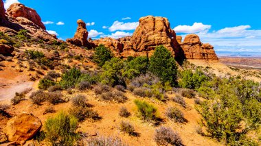 Birleşik Devletler 'in Utah kentindeki Moab kasabası yakınlarındaki Arches Ulusal Parkı' ndaki Windows Bölümü 'ndeki İlkel Döngü üzerindeki Eşsiz Kırmızı Kum Taşı Çamurları ve Kaya oluşumları' nda yürüyüş.