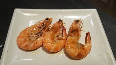 Beyaz plaka üzerinde ızgara karides