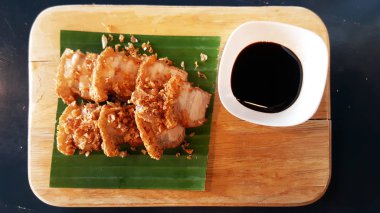 Muz yaprağı ve ahşap plaka üzerinde hizmet veren Çin gevrek domuz tatlı siyah sos tarifi