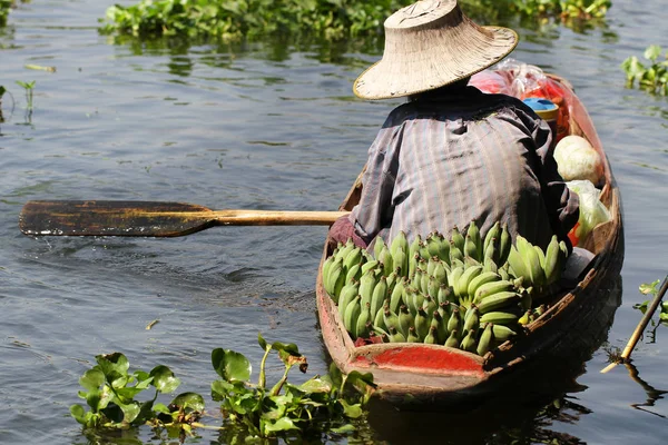 Farmář pracovní plachtění na malé lodi pro prodej bio čerstvý banán na řece plovoucí trh — Stock fotografie