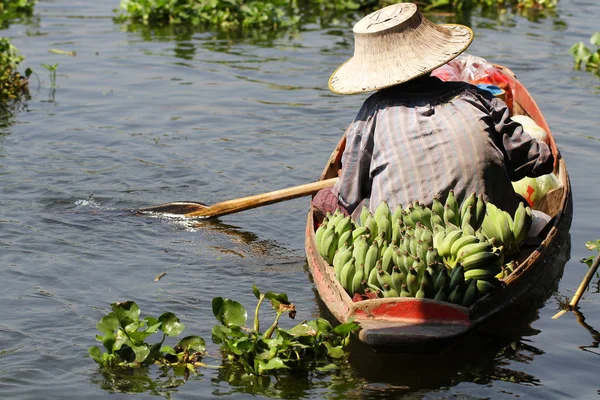 Farmář pracovní plachtění na malé lodi pro prodej bio čerstvý banán na řece plovoucí trh — Stock fotografie