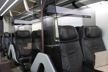 Yolcunun birinci sınıf kahverengi deri koltuğu yüksek hızlı trende, boş lüks araç koltuğu, toplu taşıma arka planı.