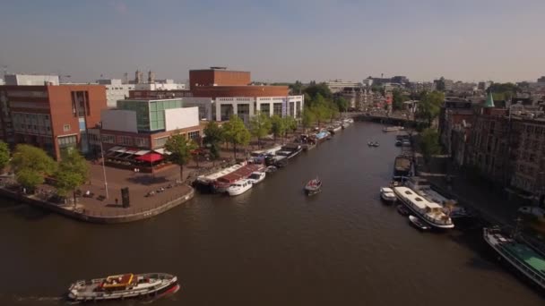 Aerial. Tour boats on water channel in Amsterdam. Camera moves forward. 4K — Stock Video