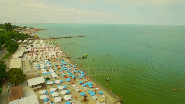 Vista aérea. Popular playa de la ciudad. Muchos sombrillas en la costa, 4K — Vídeos de Stock