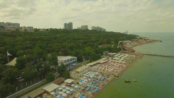 Légifelvételek. Népszerű városi strand. Sok napernyők a tengerparton, 4k — Stock videók